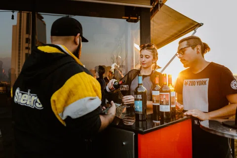 Activación de marca con servicio de bebidas y asistentes frente a un mesón.