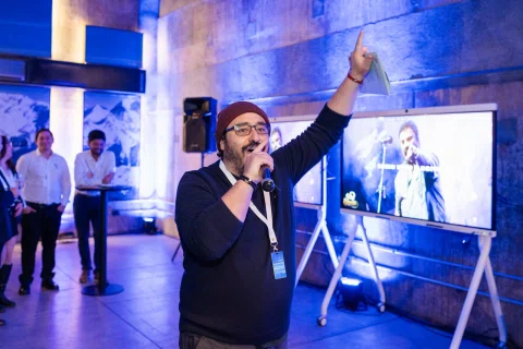 Animador habla con micrófono durante una activación frente al público.