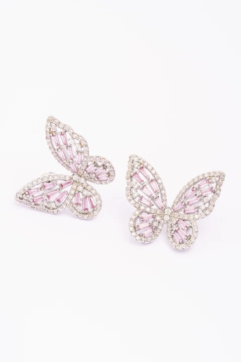 Aros de mariposa con piedras rosadas sobre fondo blanco.