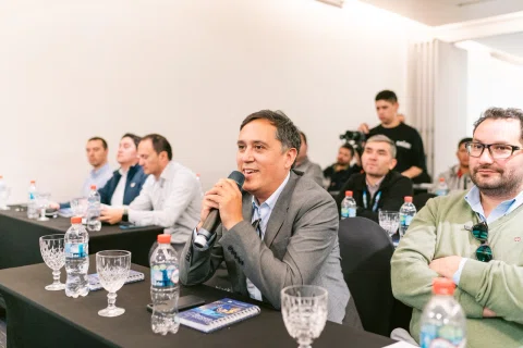 Asistente hace una pregunta con micrófono desde su mesa.