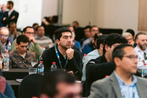 Asistente formula una pregunta con micrófono durante una conferencia.