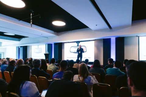Audiencia observa una charla con pantalla central.