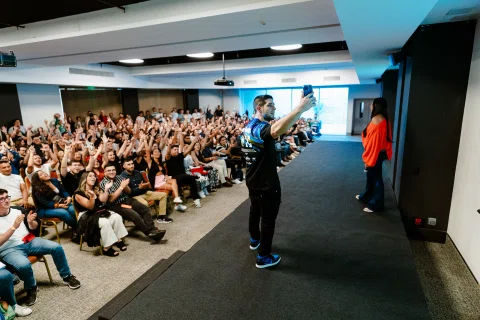Audiencia levanta las manos durante una charla participativa.