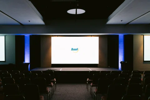 Auditorio vacío preparado con una pantalla de bienvenida.