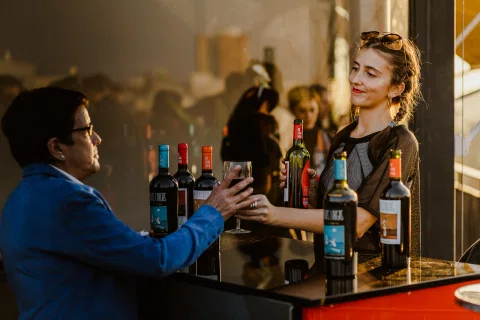 Bartender atiende a un invitado en una barra durante el evento.