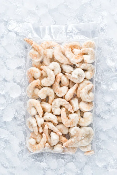 Bolsa transparente con camarones congelados.