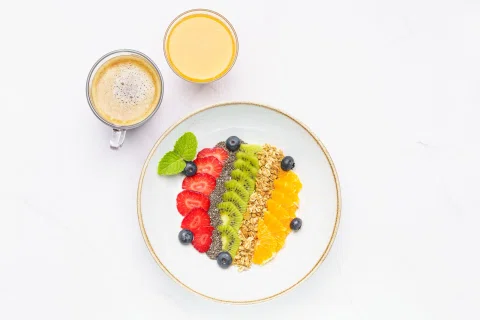 Bowl de frutas, granola y semillas fotografiado en vista cenital.