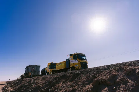Camiones transportando transformador por paisaje desértico.