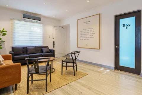 Sala de espera de una clínica o consulta médica con sillones y mobiliario interior.