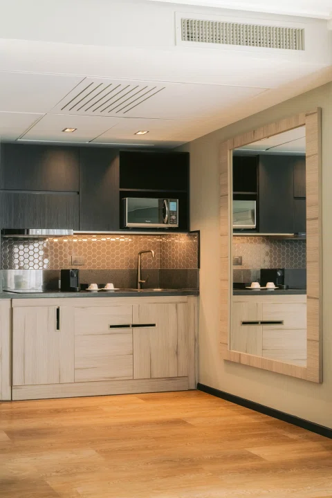 Cocina integrada de habitación con muebles claros.