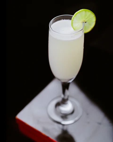 Cóctel blanco con rodaja de limón.