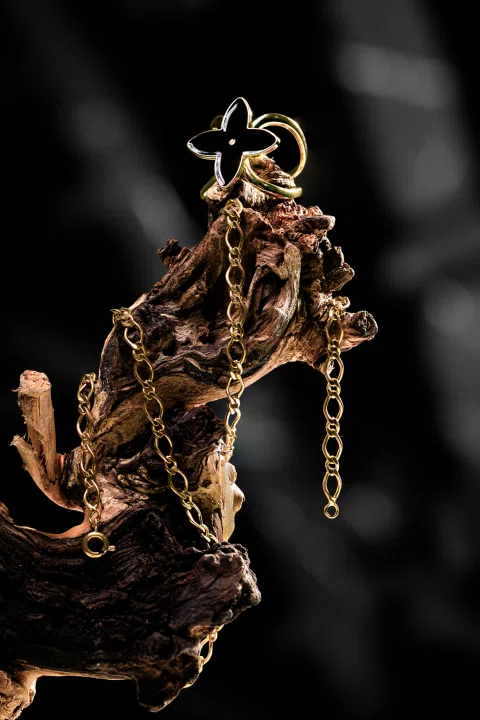 Colgante artesanal presentado sobre madera oscura.