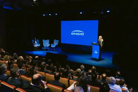Conferencia de aniversario corporativo frente a un auditorio.