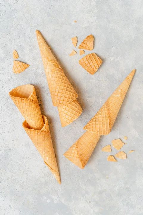 Conos de helado vacíos dispuestos sobre mesa.