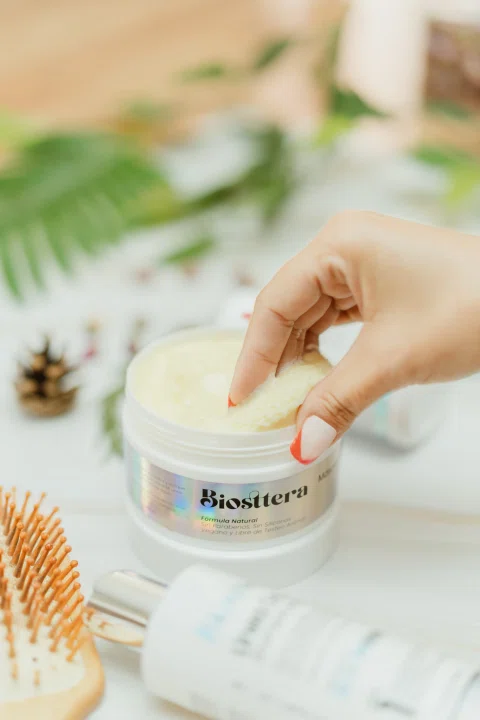 Mano utiliza una crema cosmética en una escena lifestyle.