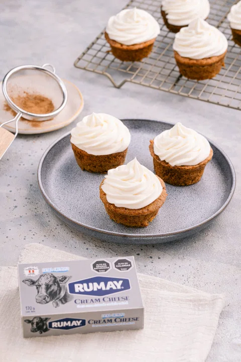 Cupcakes con merengue junto a envase de producto.