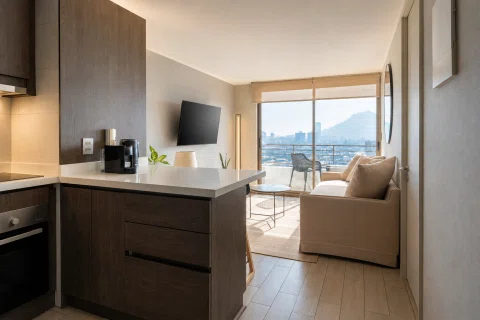 Departamento tipo Airbnb con cocina integrada, living y balcón iluminado.