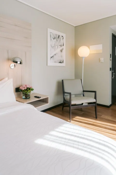Detalle de cama y zona de estar en habitación.