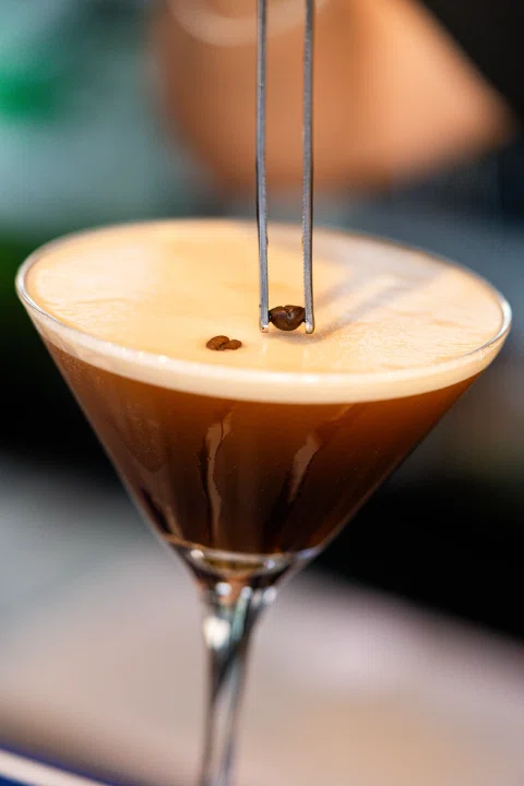 Detalle de cóctel oscuro con espuma.