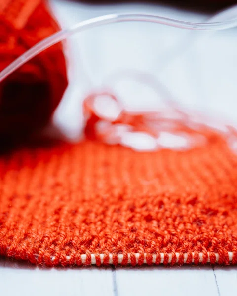 Detalle macro de tejido naranja en proceso.