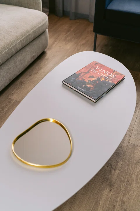 Detalle de mesa de centro con libro y aro decorativo.