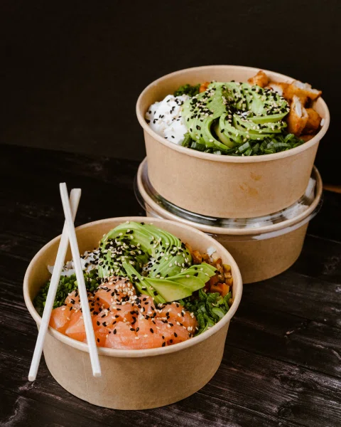 Dos bowls de arroz con salmón palta y toppings.