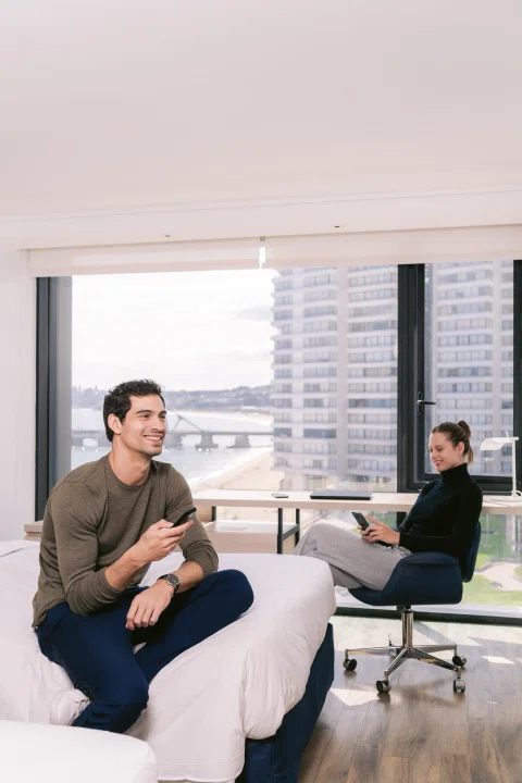 Dos huéspedes conversando en habitación.