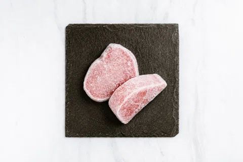Dos mochis rosados presentados sobre una pizarra negra.
