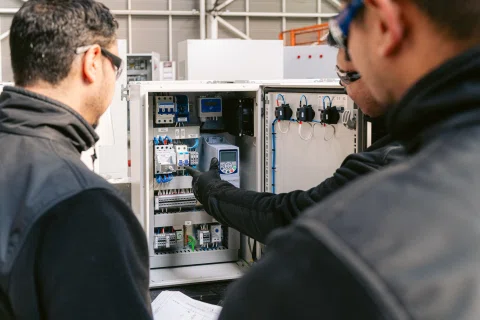Dos técnicos configurando equipo dentro de gabinete.