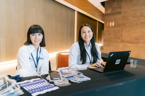 Equipo de acreditación posa detrás de la mesa de registro.