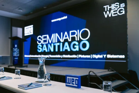 Escenario preparado para un seminario con pantalla principal y podio.