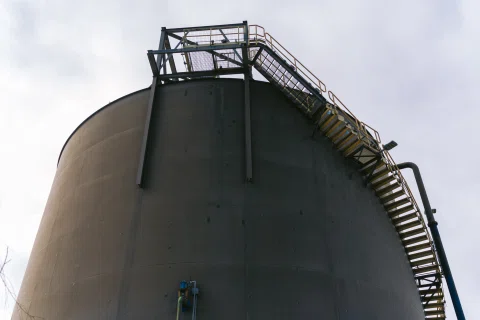 Estructura cilíndrica industrial con escalera exterior.