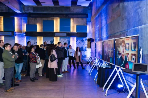 Espacio de exhibición con pantallas interactivas y asistentes.