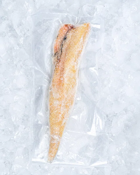 Filete de pescado en envase transparente sobre hielo.
