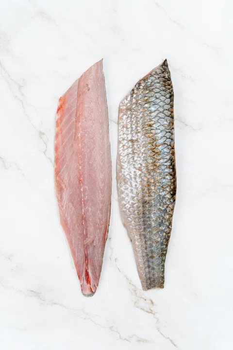 Filete rosado y piel de pescado dispuestos en paralelo.