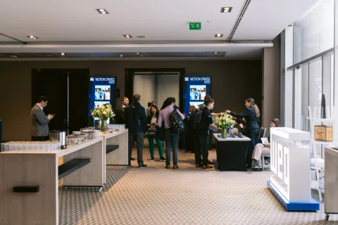 Foyer con servicio de catering y asistentes conversando durante una pausa.