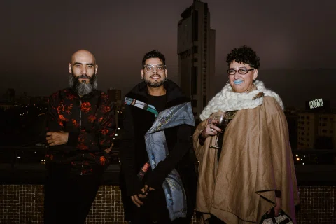 Grupo de invitados posa durante un evento nocturno al aire libre.