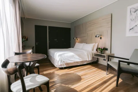 Habitación amplia con cama comedor y piso de madera.