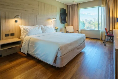 Habitación matrimonial con cama y ventanal amplio.