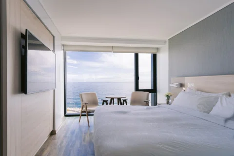 Habitación matrimonial con vista al mar desde la cama.
