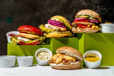 Hamburguesas de distintos colores presentadas en una composición publicitaria.