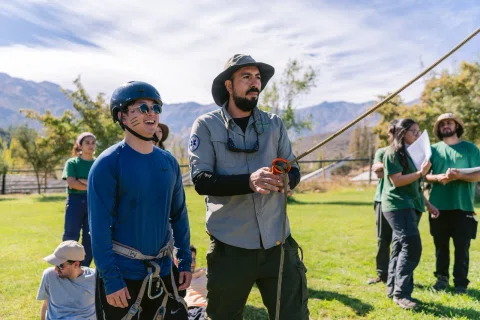 Instructor guía una actividad con cuerda y equipo de seguridad.