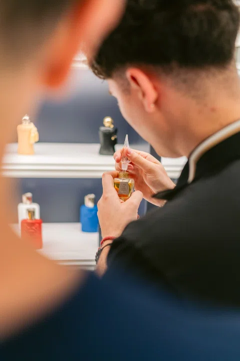 Invitado huele una fragancia durante una experiencia de producto.