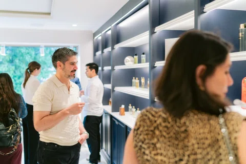 Invitado prueba una fragancia durante la inauguración de una perfumería.