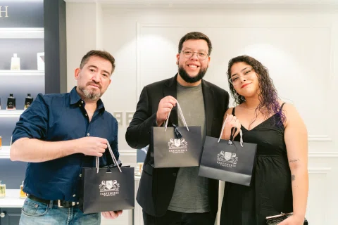 Tres invitados posan con bolsas de compra durante la inauguración.