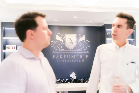 Invitados conversan dentro de una perfumería durante su inauguración.