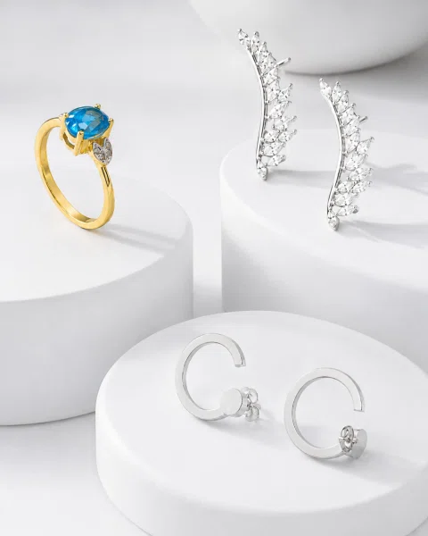 Composición de anillos y aros sobre pedestales blancos.