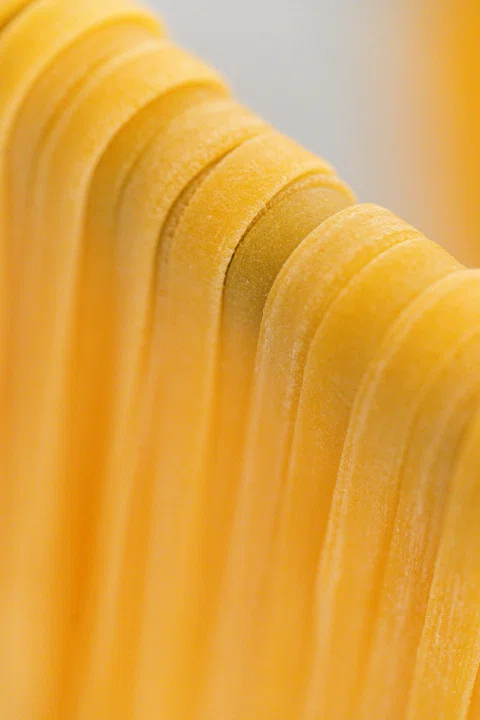 Láminas de pasta fresca colgando en paralelo.