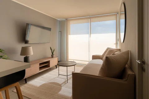 Living de departamento con ventanal amplio y luz natural.