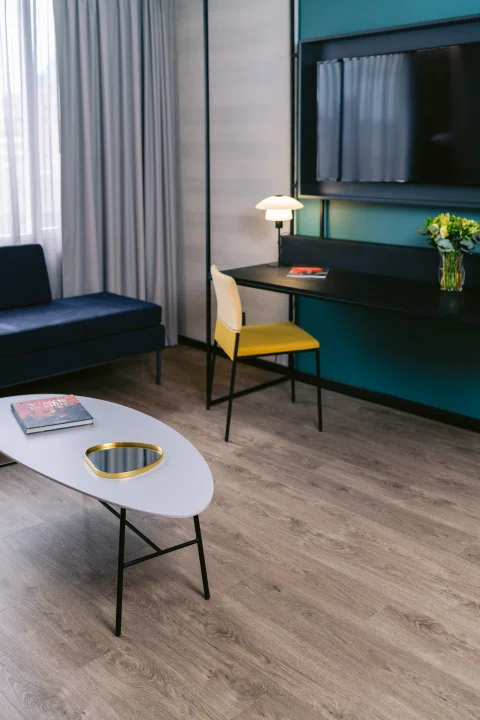 Living de habitación con sofá mesa y sillón verde.